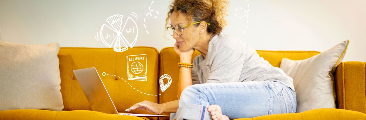 woman on couch using laptop to plan a trip