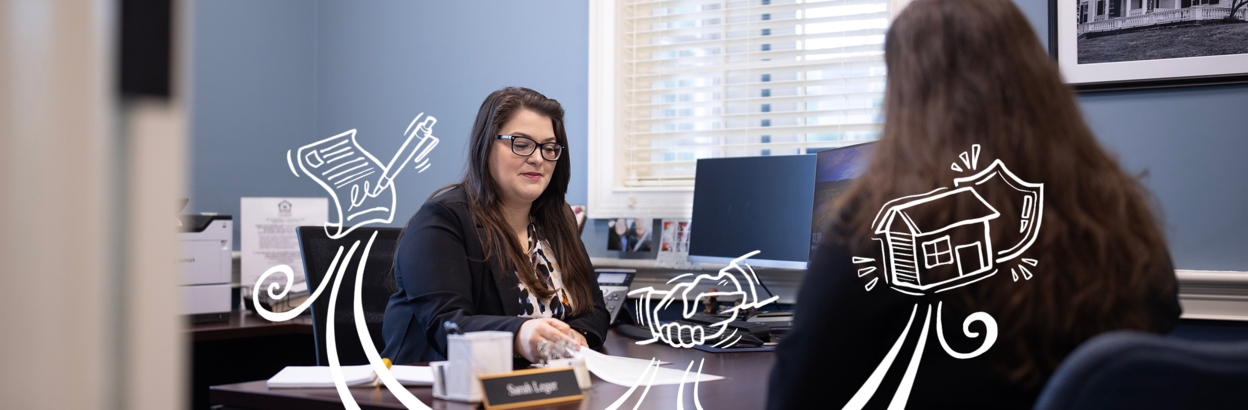 A Thomaston Savings Bank employee working with a customer and doing paperwork at desk