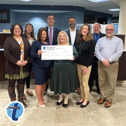 Thomaston Savings Bank executives and recipients of the Act to Impact grant pose for a photo holding a big check awarded by the bank.
