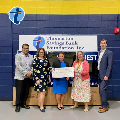 People holding a check and smiling to the camera