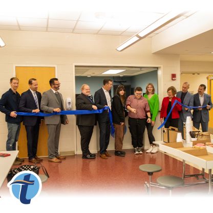 Thomaston Savings Bank employees, as well as Thomaston High School students and staff, cut a ribbon in the school's lunchroom.