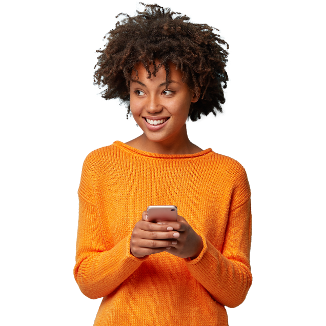 Smiling young woman in an orange sweater holding her cell phone