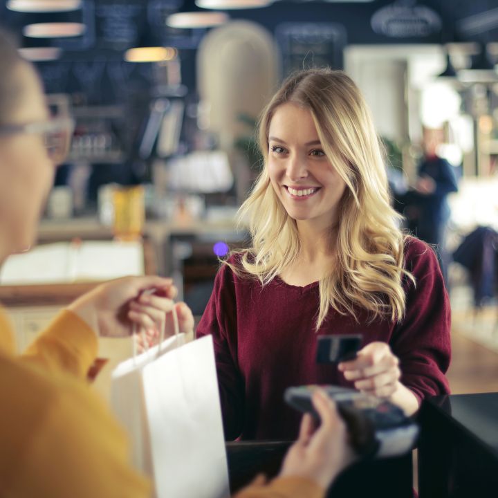 A woman shopping in a store and paying with her debit card